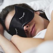 Portrait of young woman with sleep mask in bed