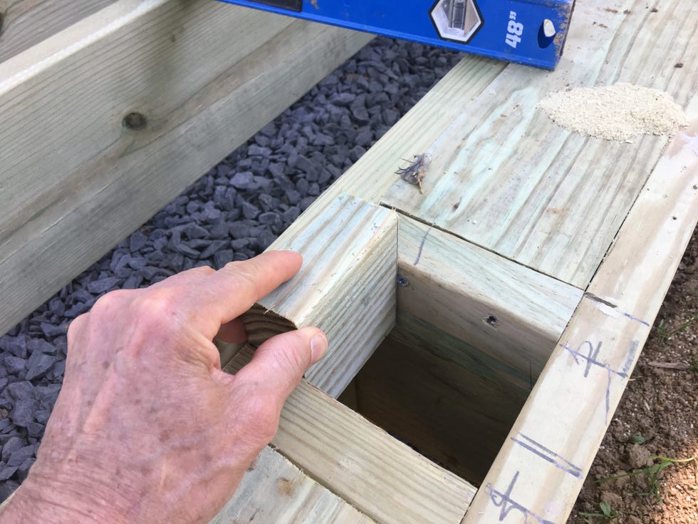 a hand holding a piece of wood