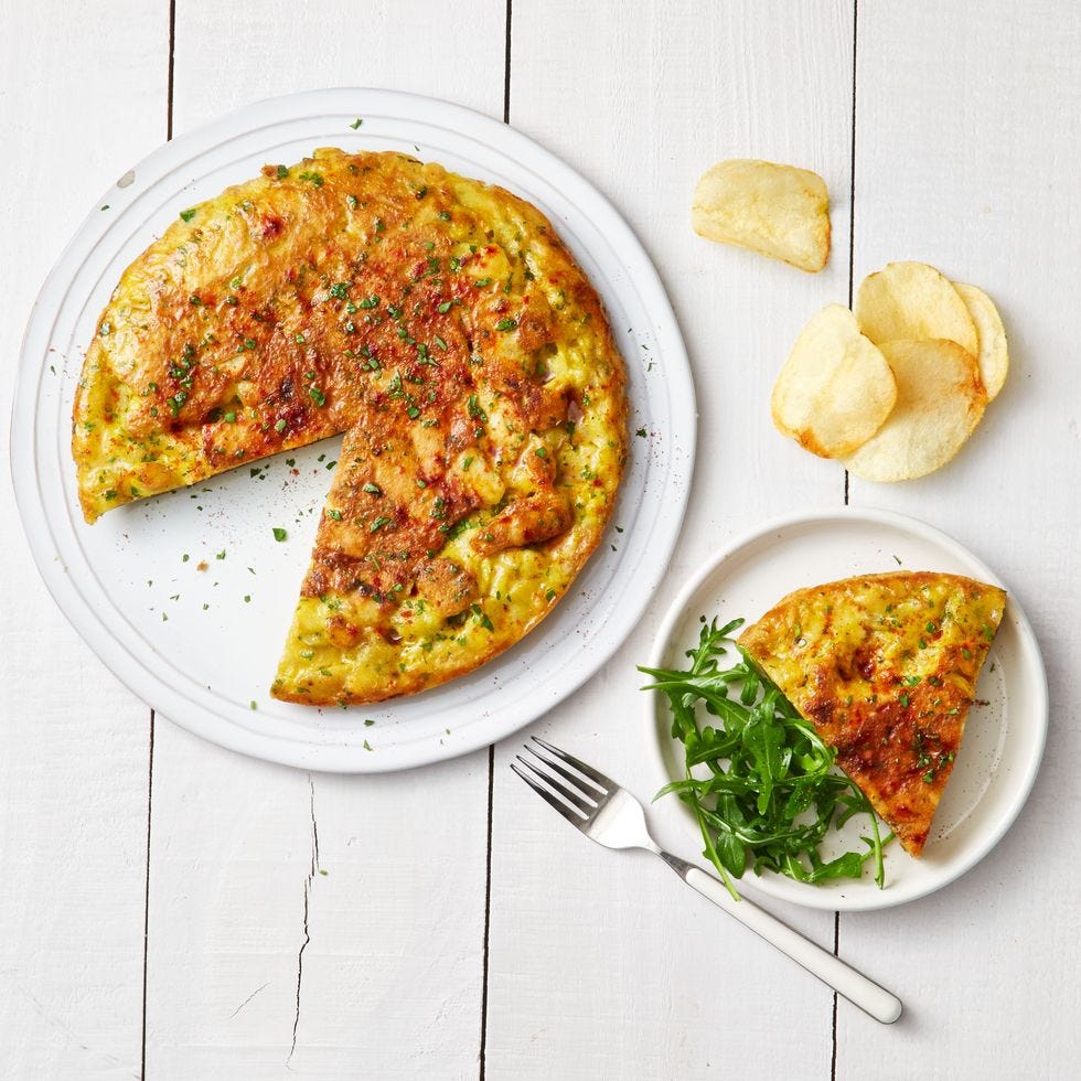 potato chip omelet on a white plate and a side of arugula