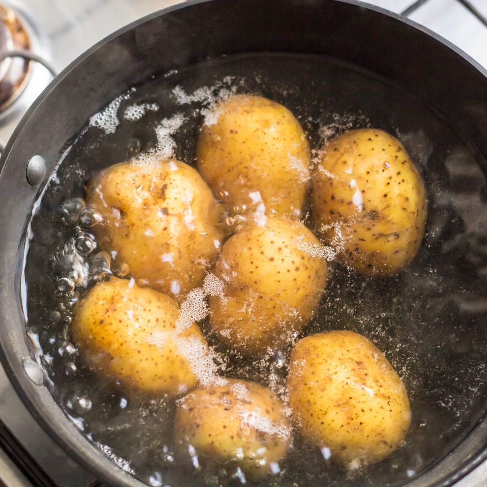 potatoes boiling in a saucepan on a gas hob