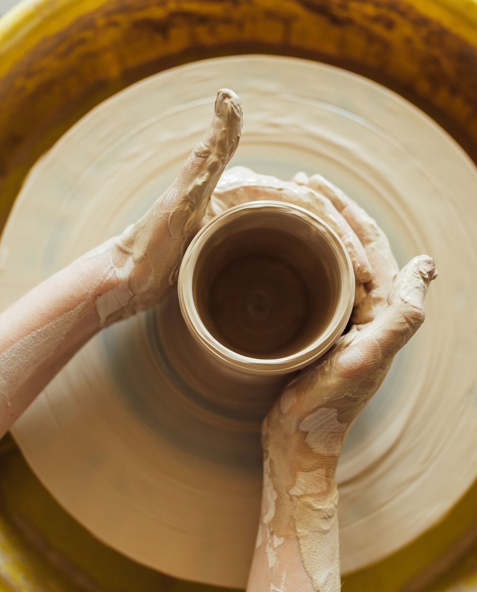 hands of a potter potter making ceramic pot on the pottery wheel