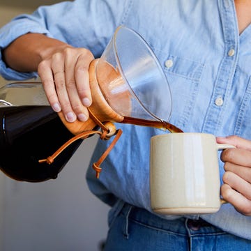 woman pouring coffee into mug from pour over coffee maker