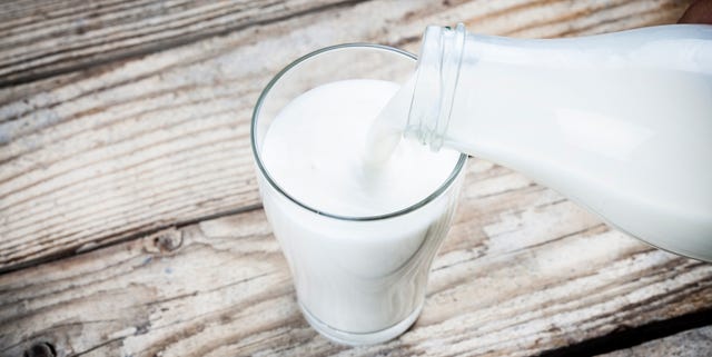 Pouring a glass of milk wooden table