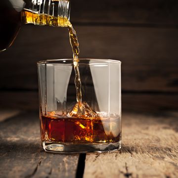 pouring glass of whiskey, close up whisky on the rocks