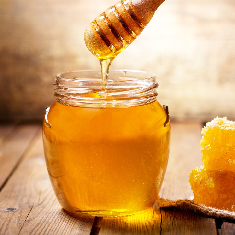 pouring honey into jar of honey