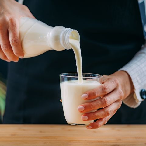 pouring kefir into glass, a healthy fermented dairy drink