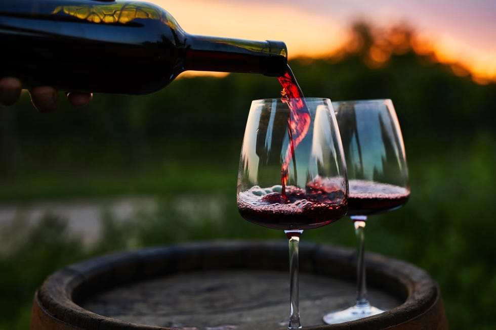 https://hips.hearstapps.com/hmg-prod/images/pouring-red-wine-into-glasses-on-the-barrel-royalty-free-image-1691076620.jpg?resize=980:*