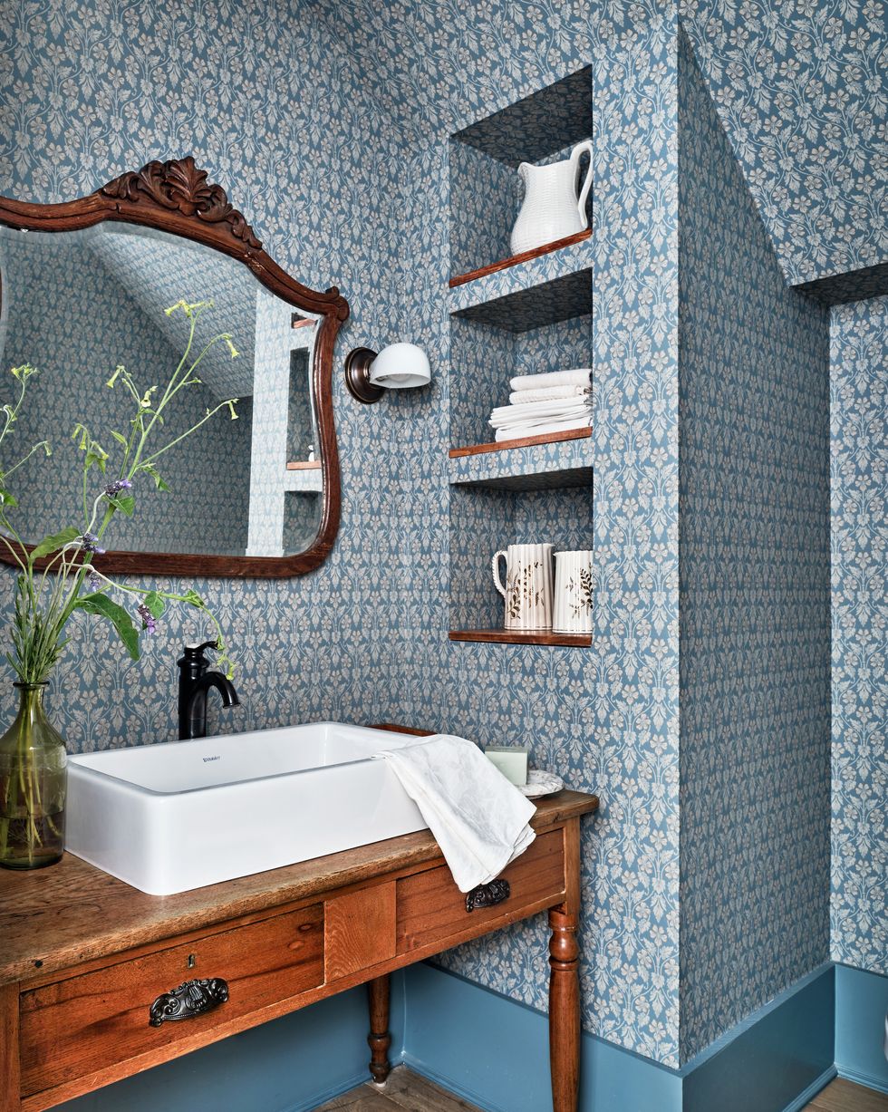 powder bath with antique table vanity and wallpaper