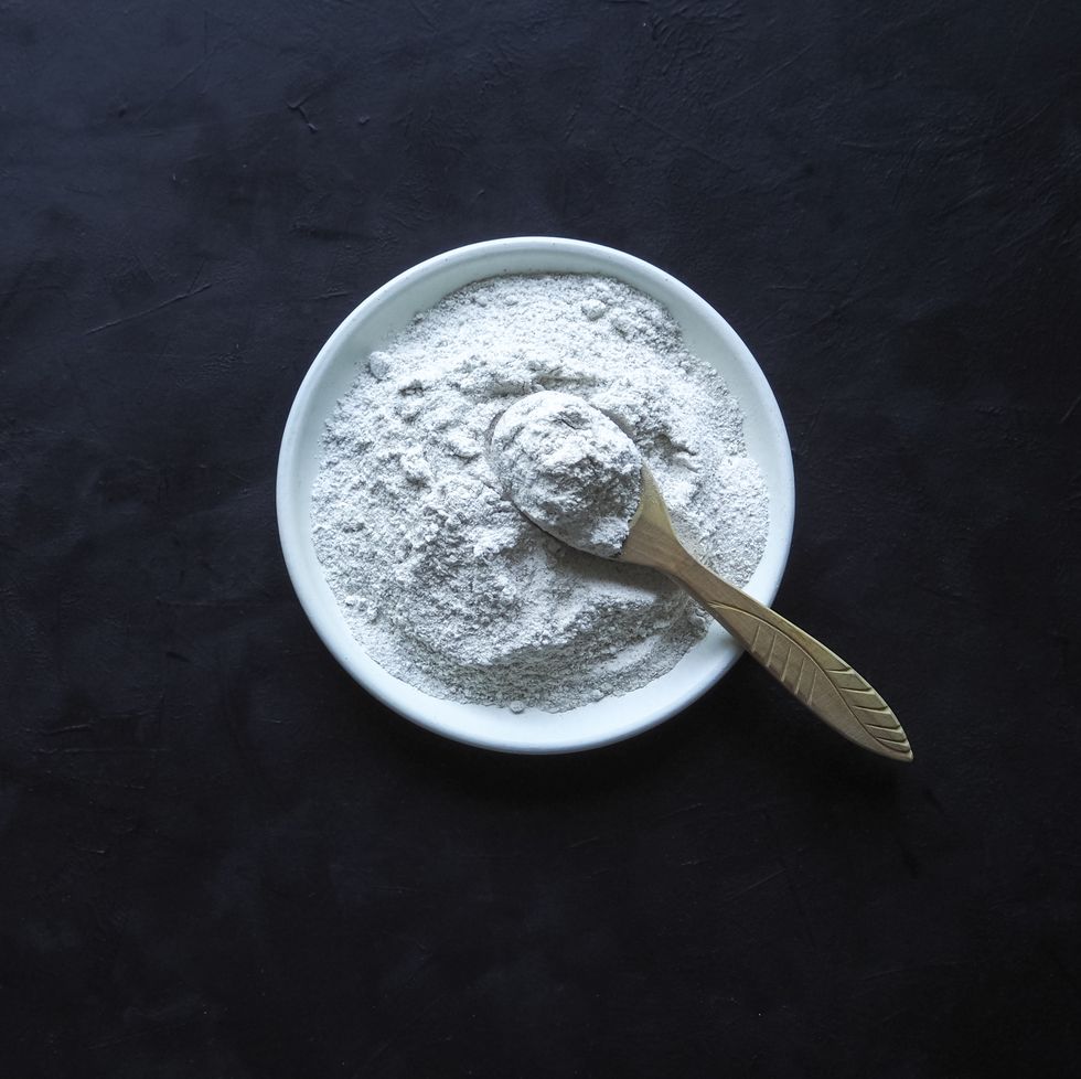 Powdered maca root in a bowl with wooden spoon.