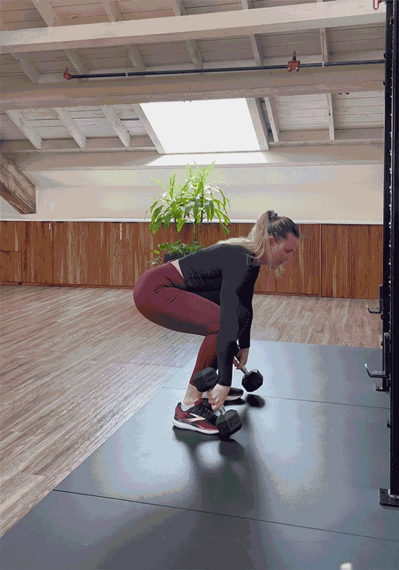 woman doing power clean with dumbbells