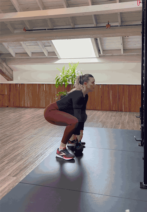 woman doing power clean with kettlebell