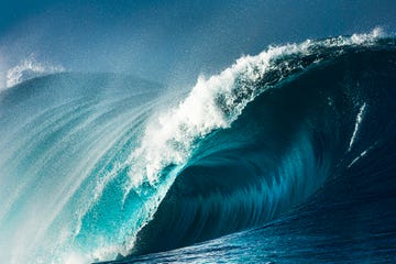 powerful blue and aquamarine wave breaking in the open ocean on a sunny day