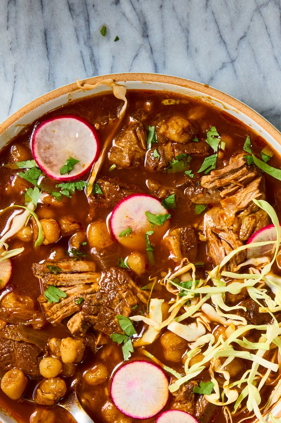 pozole with pork shoulder topped with cabbage and radishes