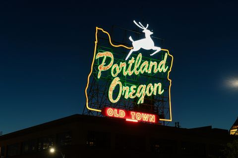 portland white stag sign illuminated at night over burnside bridge the sign can be spotted on top of old town's white stag building