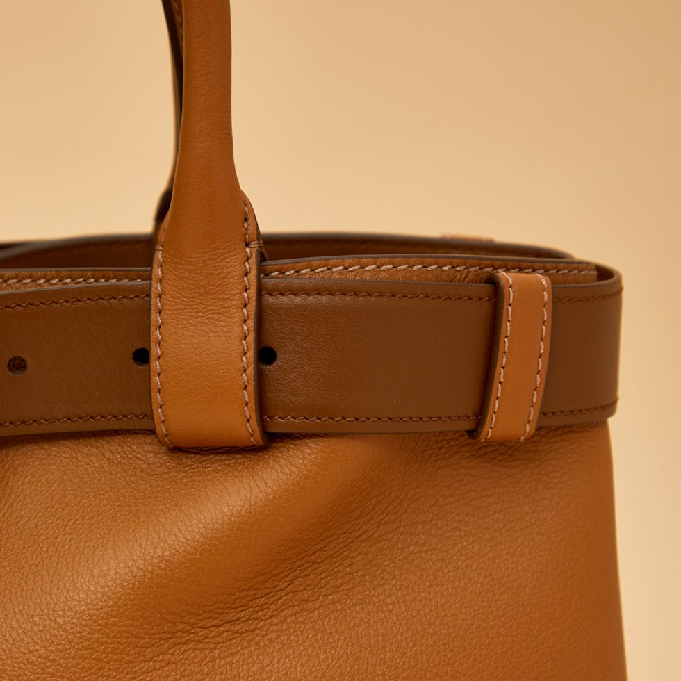 closeup of a brown leather handbag handle and edge