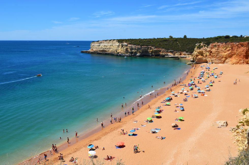 O Algarve, a praia de Portugal conhecida como Praia Nova, tem areia laranja e água azul deslumbrante