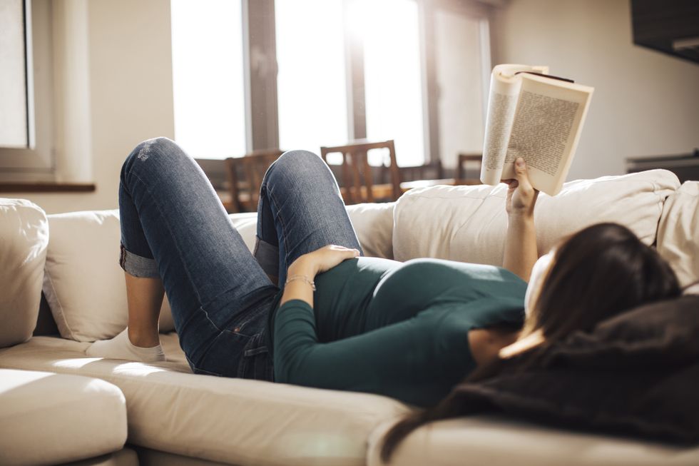 pregnant woman reading a book while lying down