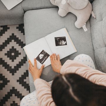 woman adding ultrasound photos to pregnancy journal