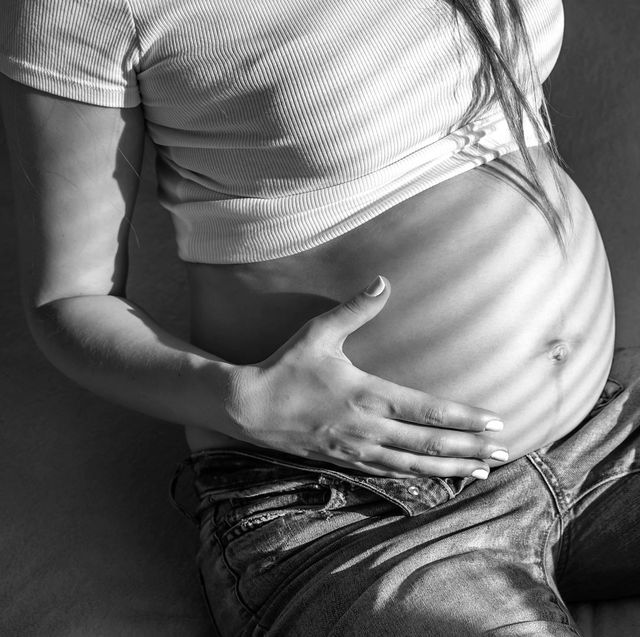 a pregnant woman holds her stomach