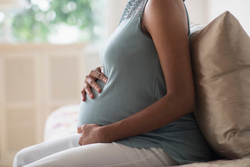 pregnant african american mother holding her stomach