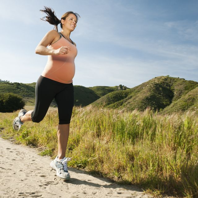 pregnant hispanic woman running Badeschuhe in remote area