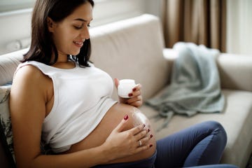 mujer embarazada aplicándose crema antiestrías