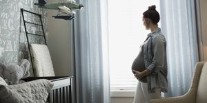 Pregnant woman looking out nursery window