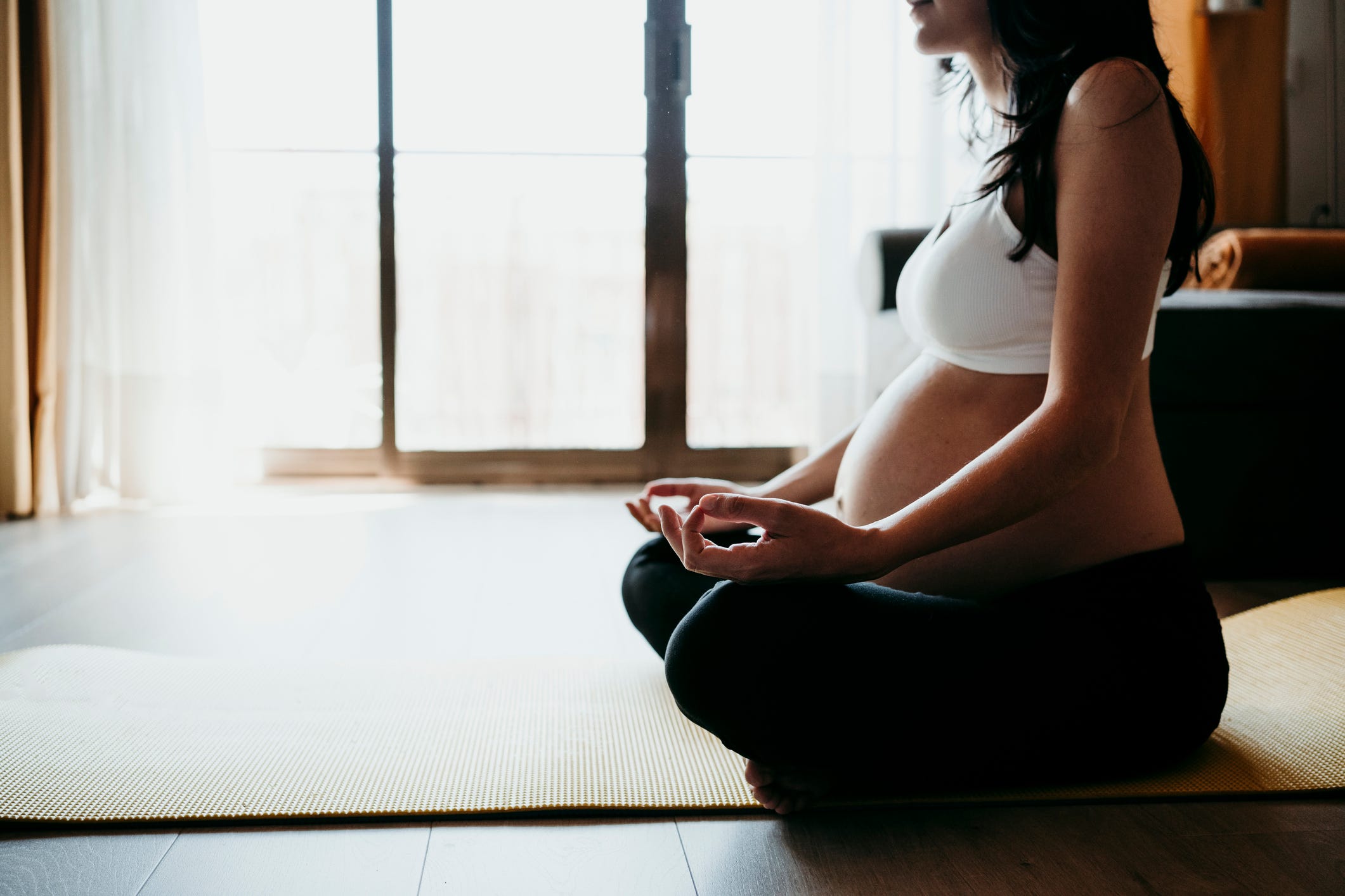 mujer embarazada haciendo yoga y meditando
