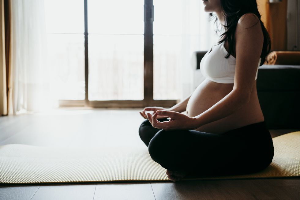 mujer embarazada haciendo yoga y meditando