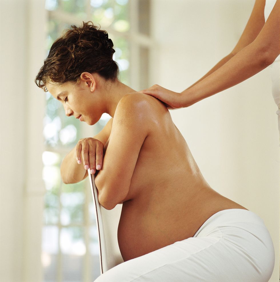 mujer embarazada recibiendo un masaje en la espalda