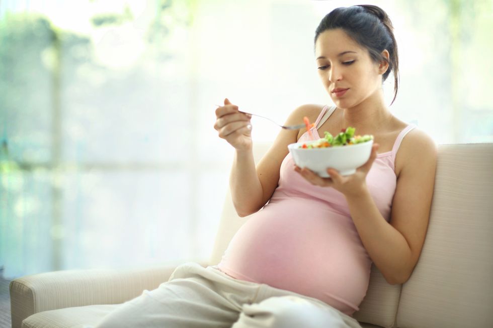 mujer embarazada comiendo una ensalada