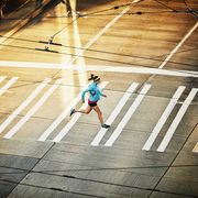 pregnant woman Run running across sidewalk during early morning run on empty city street