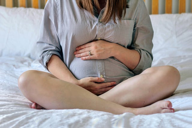 pregnant woman sitting on bed