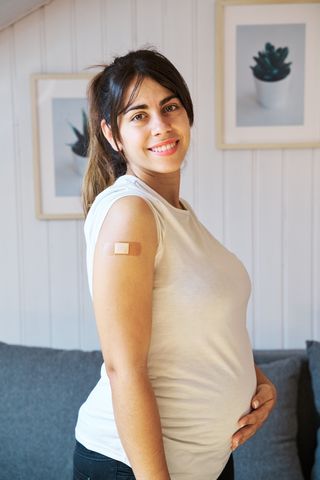 pregnant woman smiling after getting a vaccine against covid 19 virus