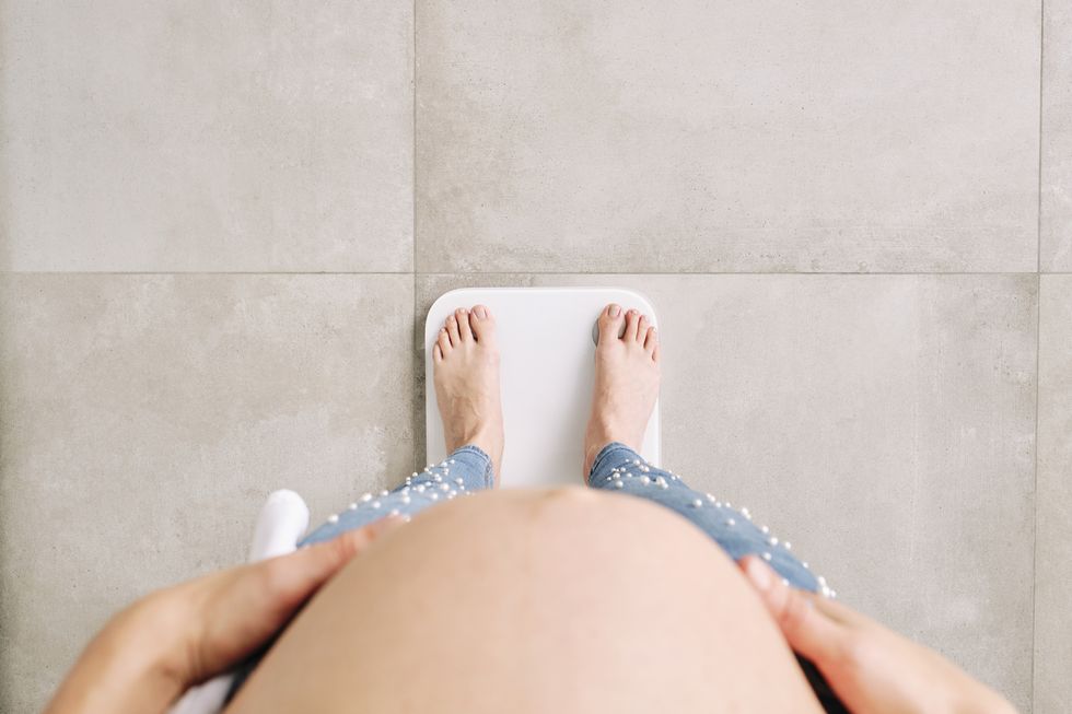 embarazada pesándose mostrando tripa