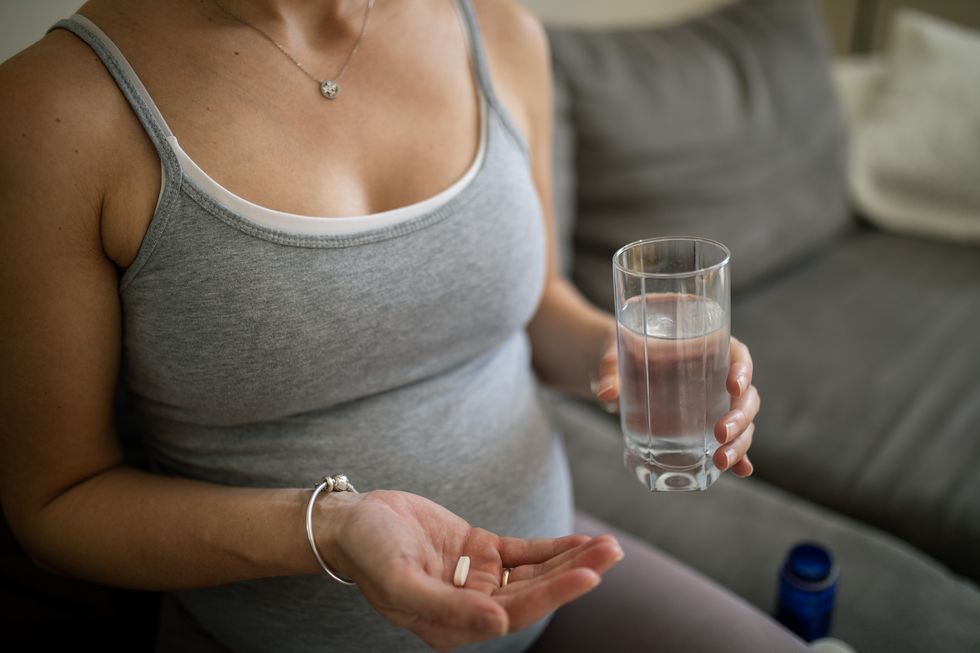 pregnant woman taking a medicine or nutritional supplement