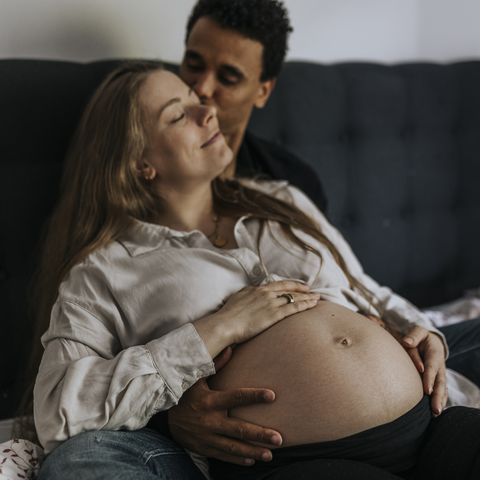 pregnant woman with partner sitting in bed