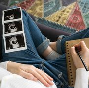 pregnant woman writing notes to her baby with ultrasound image