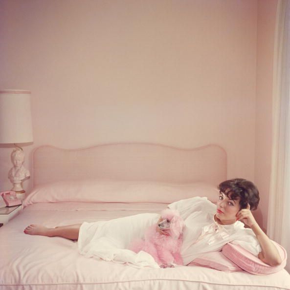 joan collins relaxes on a bed