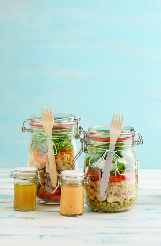 preserving jars of various mixed salad and jars of salad dressings