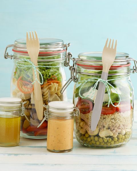 preserving jars of various mixed salad and jars of salad dressings