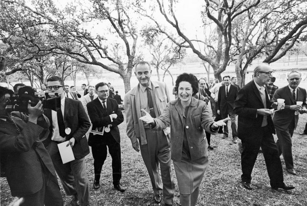 lyndon b johnson and wife lady bird surrounded by press members at their ranch in texas