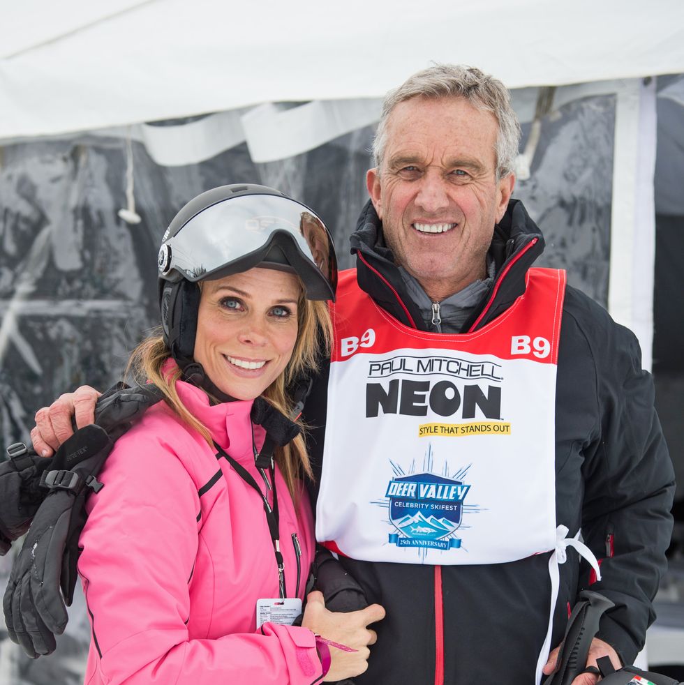 cheryl hines and robert f kennedy jr smile at the camera, they are wearing skiing apparel