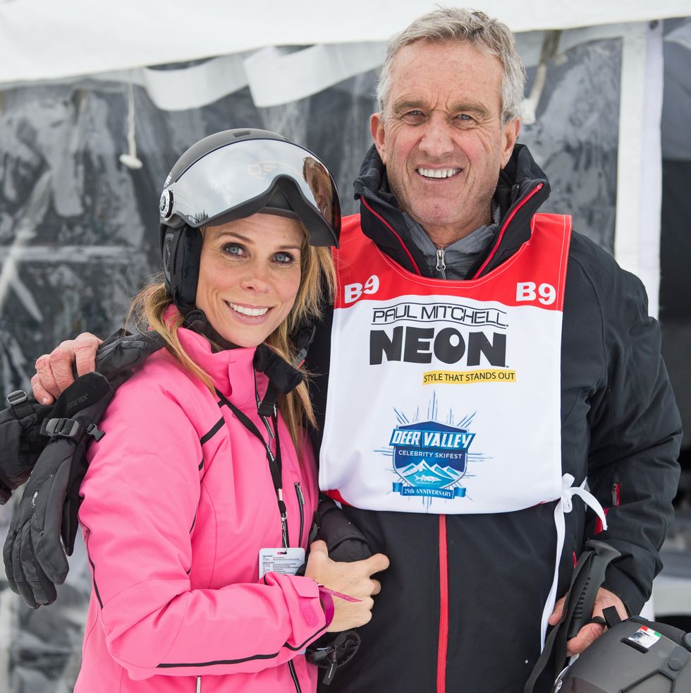 cheryl hines and robert f kennedy jr smile at the camera, they are wearing skiing apparel