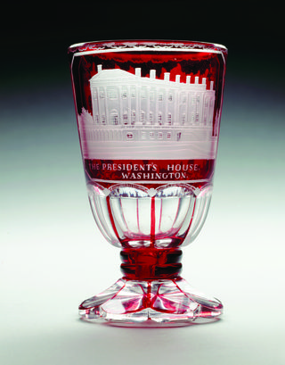 this cut and engraved ruby stained glass goblet was made in a region of europe known as bohemia between 1840 and 1860, which is now largely part of the czech republic glassware featuring american landmarks was popular at the time, and this piece features an engraving of the president's house, or white house the engraving is based on an english print of the white house created and distributed in 1831