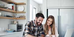 pareja joven haciendo un presupuesto en la cocina con un ordenador