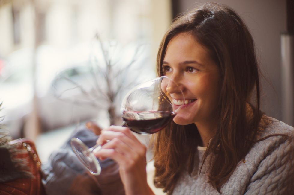 Pretty happy woman drinking wine