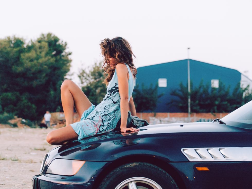 pretty sensual woman sitting over convertible car