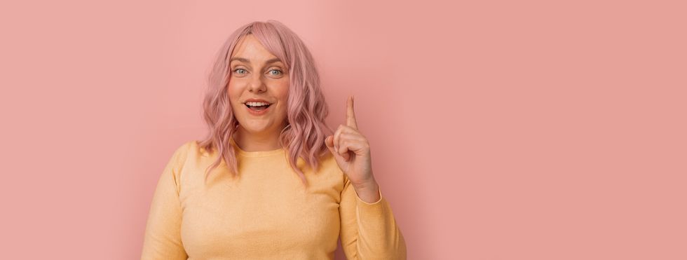 young woman with pink curly hairstyle dye posing copy empty space isolated over bright pink color background