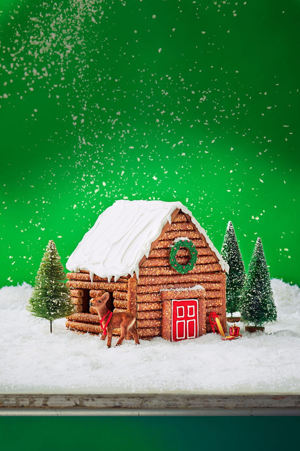 pretzel gingerbread log cabin against a green background